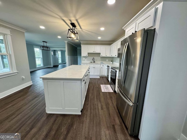 kitchen with dark wood-style floors, a center island, ornamental molding, freestanding refrigerator, and white cabinetry