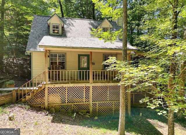 rear view of property with a shingled roof and covered porch