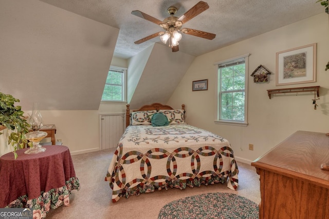 bedroom featuring a textured ceiling, ceiling fan, lofted ceiling, carpet floors, and baseboards