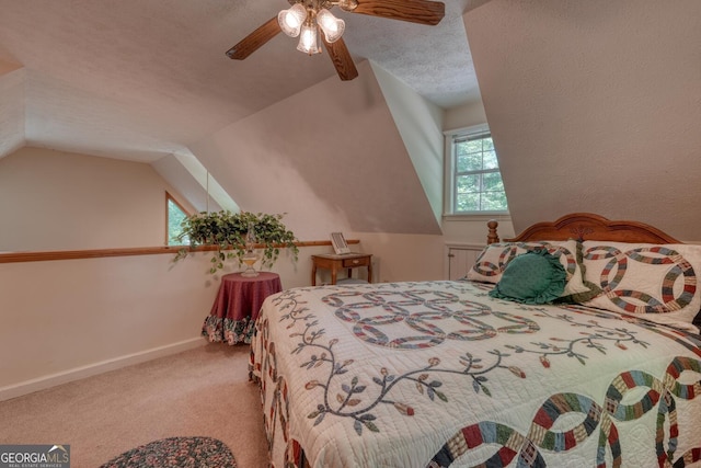 bedroom with lofted ceiling, a textured ceiling, a ceiling fan, baseboards, and carpet