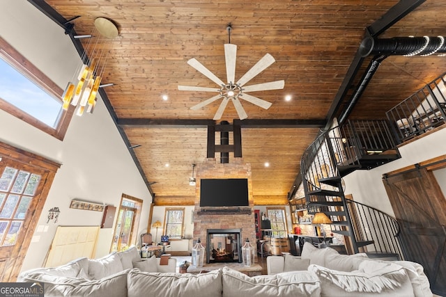 living room with a wealth of natural light, beamed ceiling, high vaulted ceiling, and ceiling fan