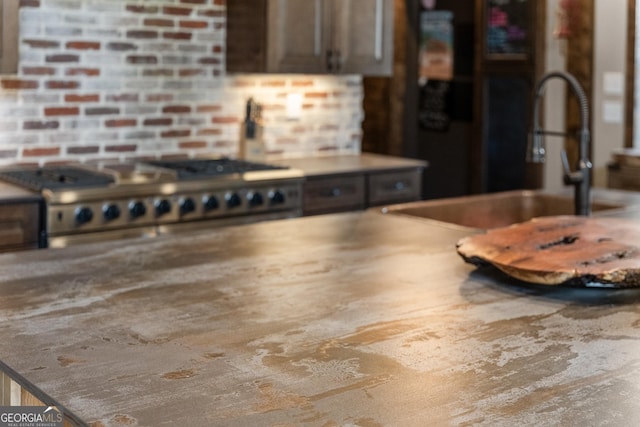 details featuring dark brown cabinets, gas range oven, and a sink