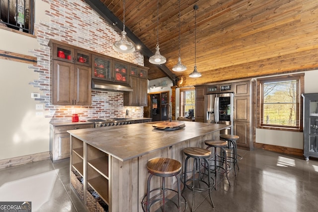 kitchen featuring under cabinet range hood, appliances with stainless steel finishes, butcher block counters, and high vaulted ceiling