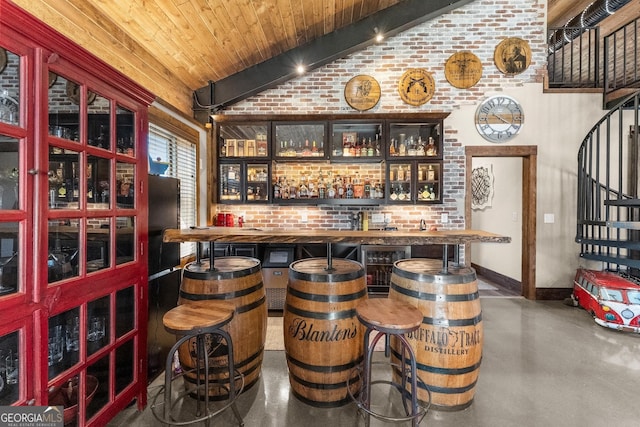 bar featuring indoor wet bar, lofted ceiling, finished concrete flooring, and brick wall