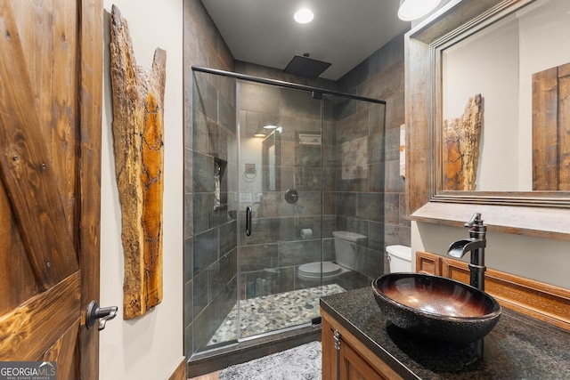 full bathroom with toilet, a shower stall, and vanity