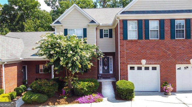 view of front of home with a garage, driveway, and brick siding