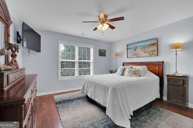 bedroom with visible vents, dark wood finished floors, baseboards, and ceiling fan