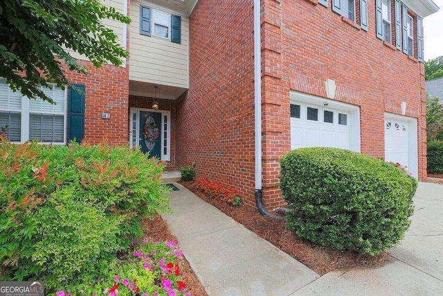 entrance to property featuring brick siding and an attached garage