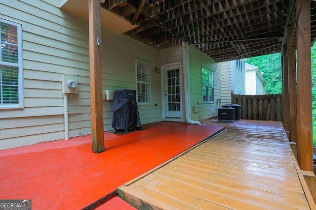 wooden deck with central AC unit and fence