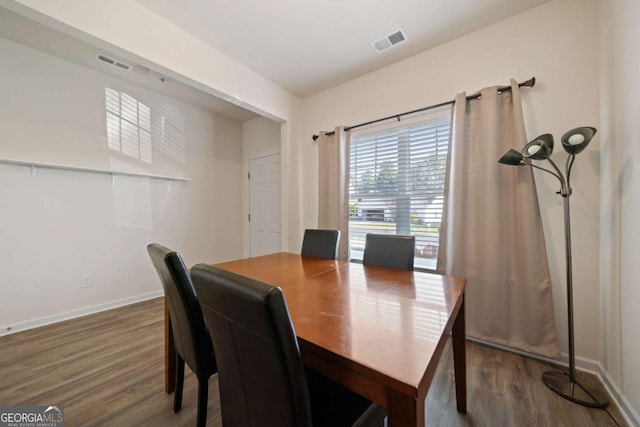 dining space with baseboards, visible vents, and dark wood-type flooring