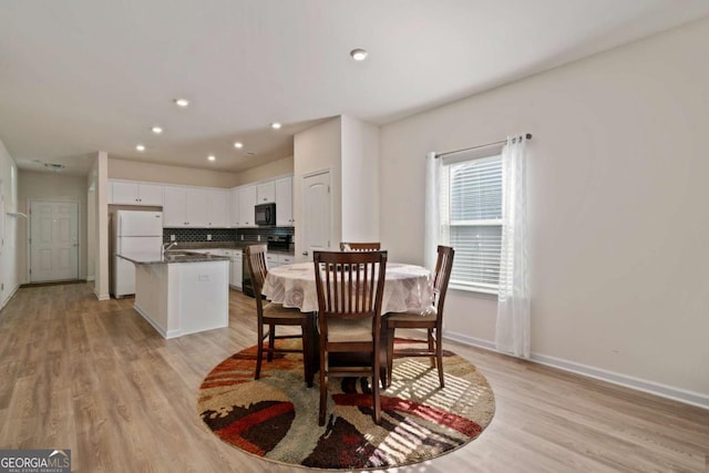 dining room featuring recessed lighting, light wood-style flooring, and baseboards