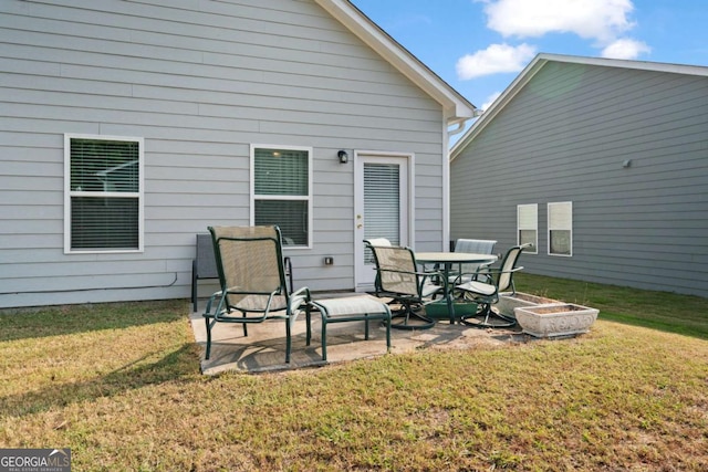 back of property featuring a lawn and a patio area