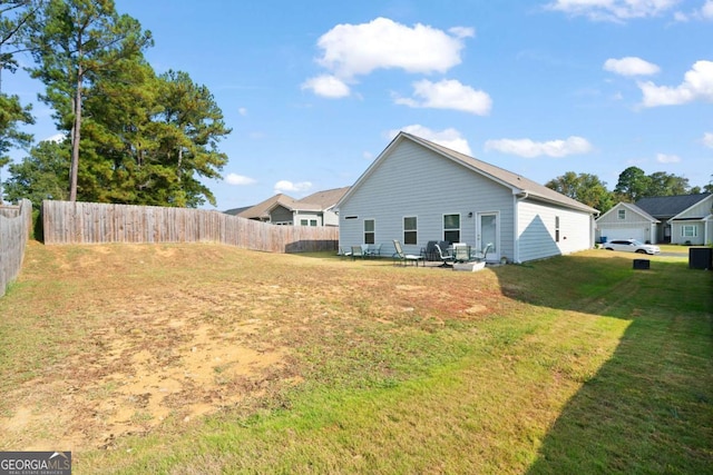 rear view of property featuring a yard and fence