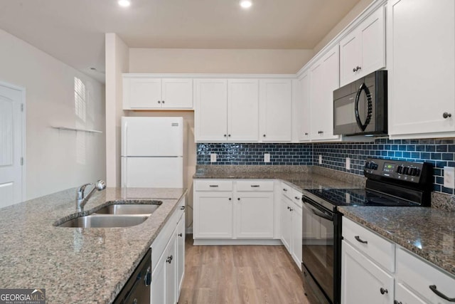 kitchen with black appliances, light wood-style flooring, a sink, and white cabinetry