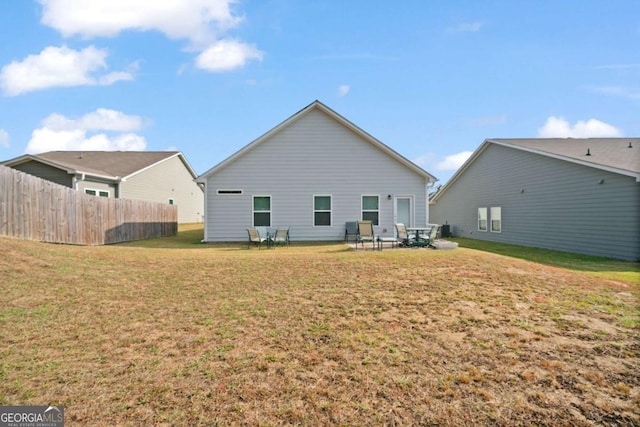 back of house featuring a yard and fence