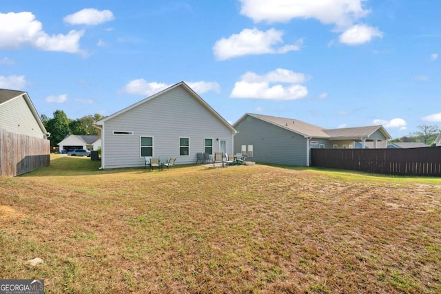 back of property featuring a yard and fence