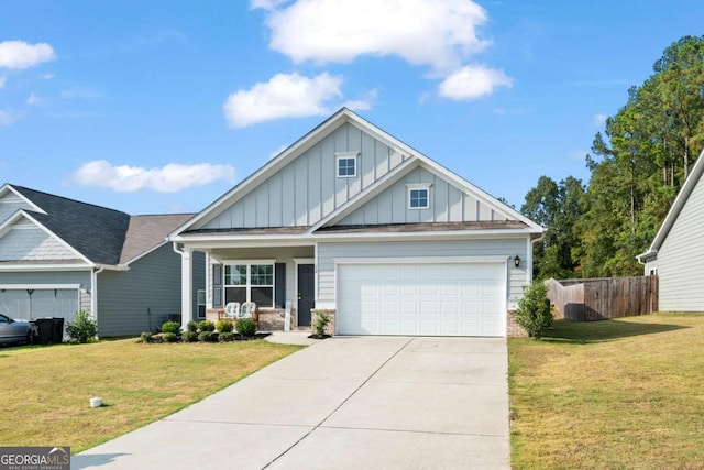 craftsman-style home featuring concrete driveway, covered porch, fence, a front lawn, and board and batten siding