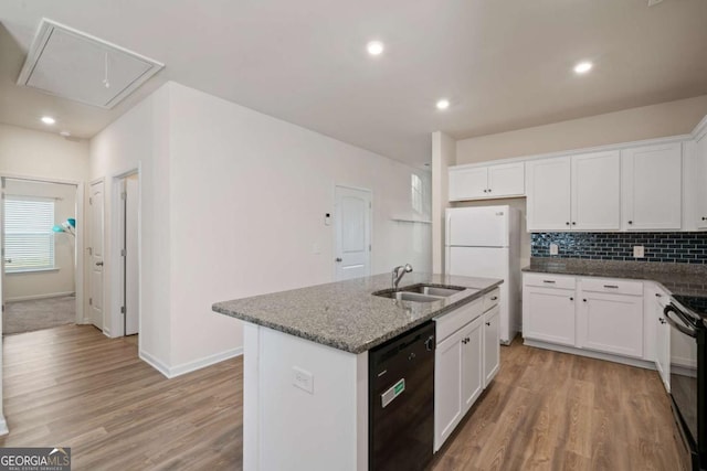 kitchen with light wood-style floors, a sink, backsplash, and black appliances