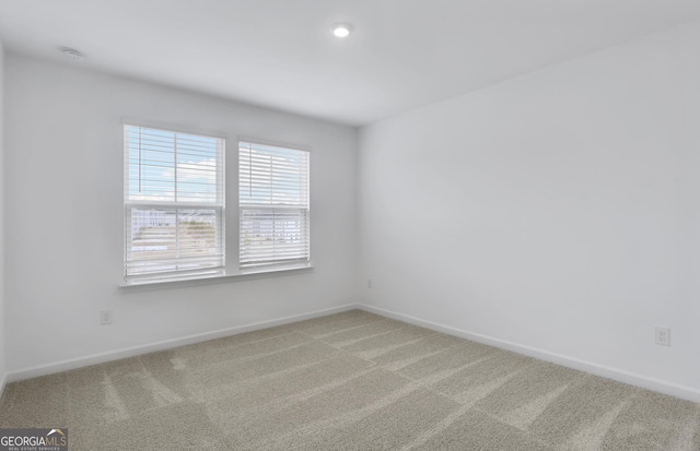 carpeted spare room featuring baseboards