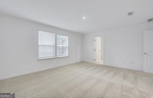 unfurnished room featuring light carpet, visible vents, and baseboards