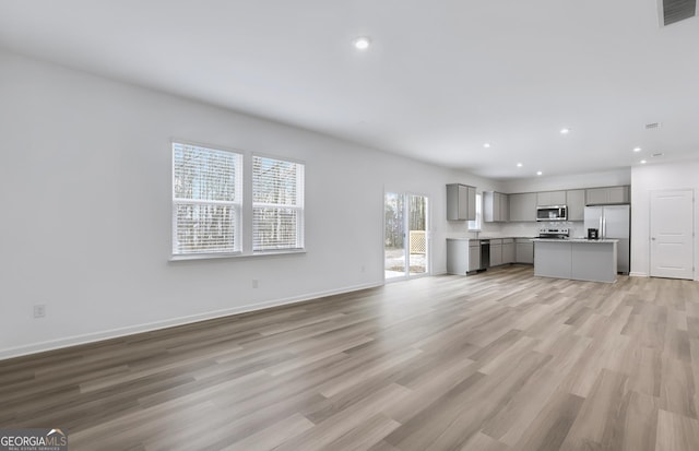 unfurnished living room with light wood-style flooring, visible vents, baseboards, and recessed lighting