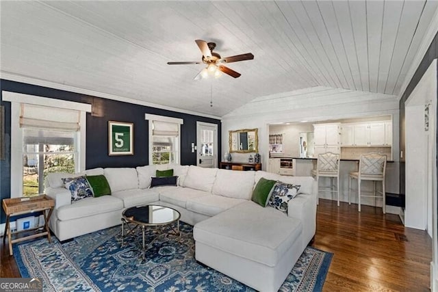 living area with dark wood-style floors, lofted ceiling, crown molding, and plenty of natural light