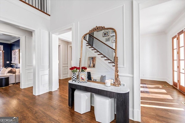 foyer with baseboards, dark wood-type flooring, stairway, and crown molding