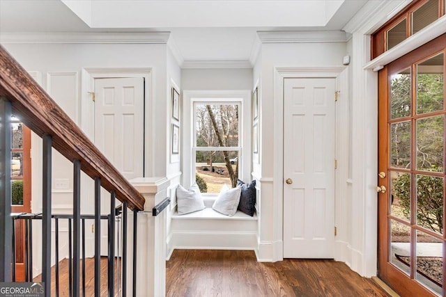 entryway featuring dark wood-type flooring, a healthy amount of sunlight, and ornamental molding