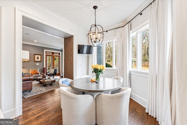 dining area featuring dark wood-style floors, a chandelier, crown molding, and baseboards