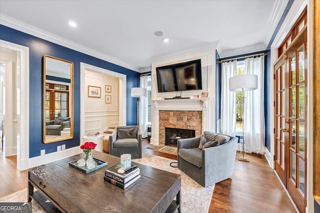 living room featuring french doors, a fireplace, wood finished floors, and crown molding