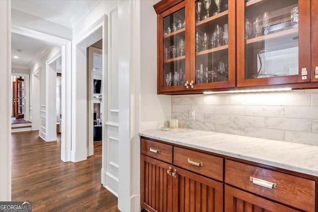 bar with ornamental molding, dark wood finished floors, and tasteful backsplash