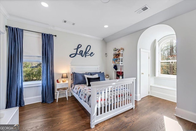 bedroom featuring ornamental molding, visible vents, and wood finished floors