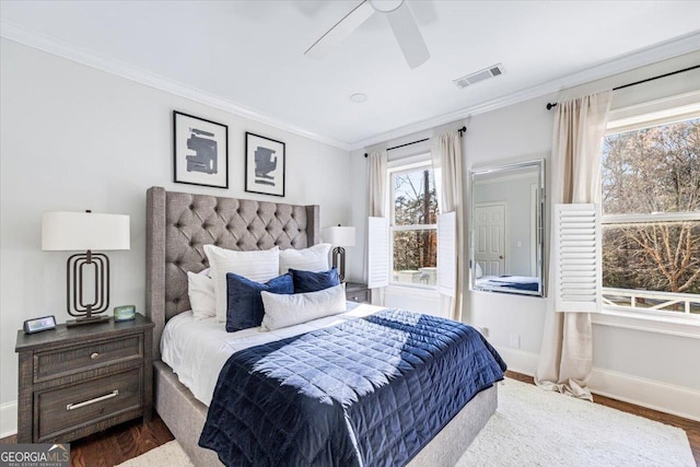 bedroom featuring ornamental molding, dark wood-style flooring, visible vents, and baseboards