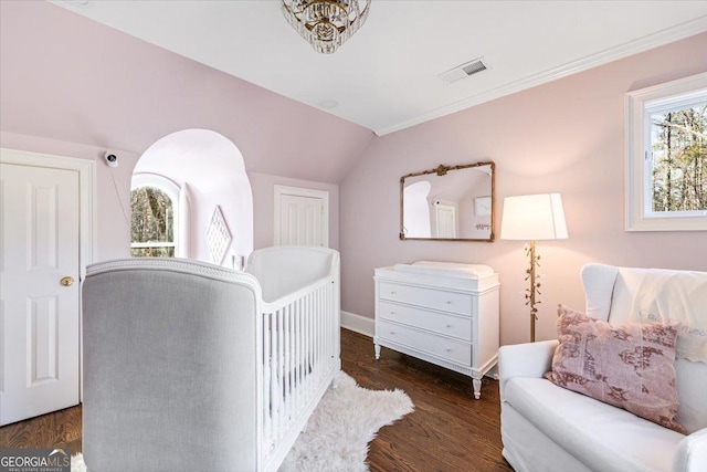 bedroom with visible vents, vaulted ceiling, and wood finished floors