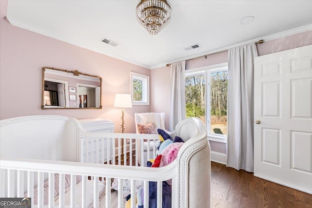 bedroom with visible vents, crown molding, a notable chandelier, and wood finished floors