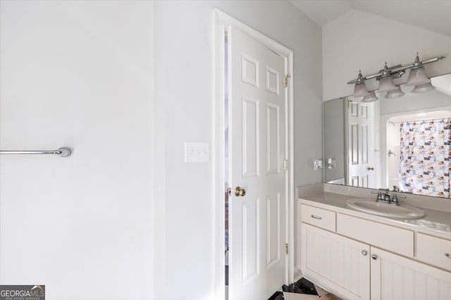 full bathroom featuring lofted ceiling and vanity