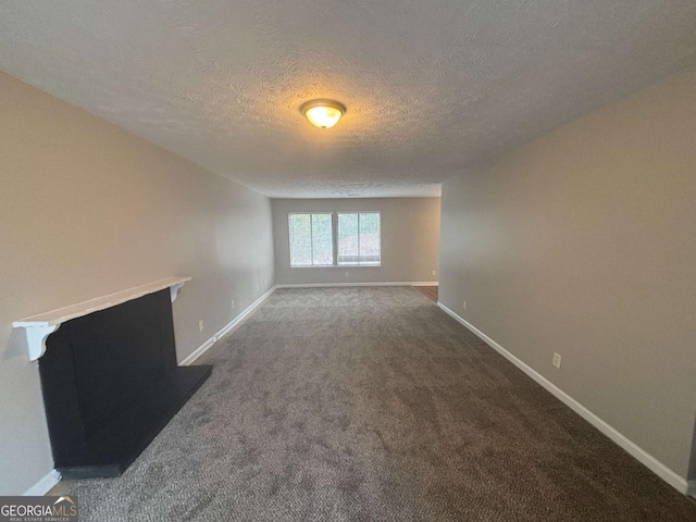 unfurnished living room featuring carpet floors, a textured ceiling, and baseboards