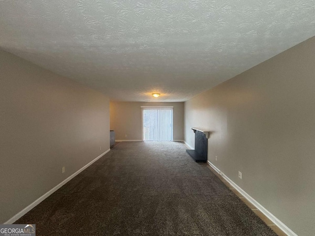 interior space featuring carpet floors, baseboards, and a textured ceiling