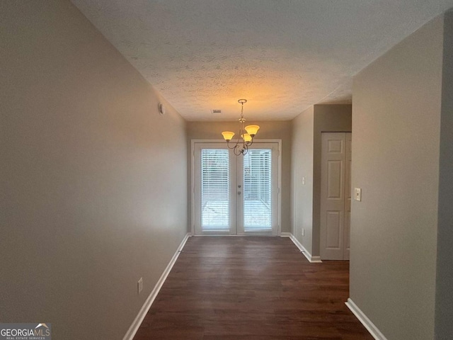 5073 Martins Crossing Rd, Stone Mountain, GA 30088 - unfurnished dining area with a chandelier, dark wood finished floors, a textured ceiling, and french doors