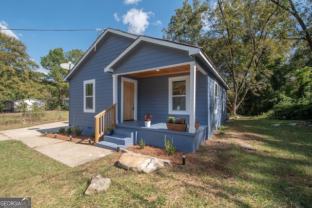 view of front facade featuring crawl space, covered porch, and a front yard