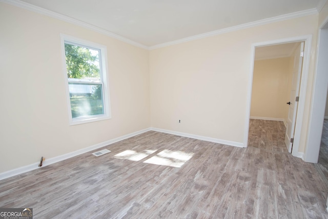 unfurnished room featuring light wood finished floors, baseboards, visible vents, and crown molding