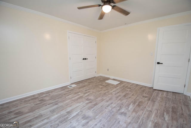 spare room with ornamental molding, wood finished floors, and baseboards