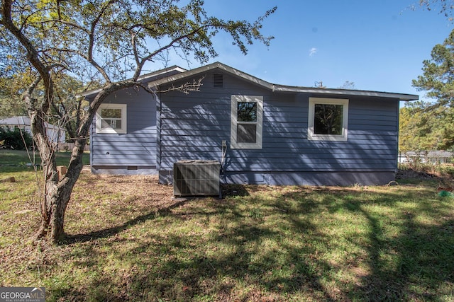 view of side of home featuring central AC, a yard, and crawl space