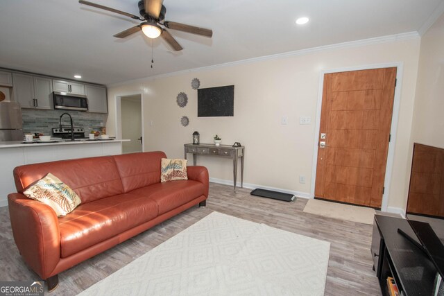 kitchen with appliances with stainless steel finishes, light countertops, ornamental molding, and gray cabinetry