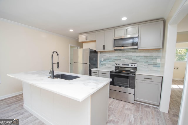 kitchen with crown molding, appliances with stainless steel finishes, gray cabinets, and a sink