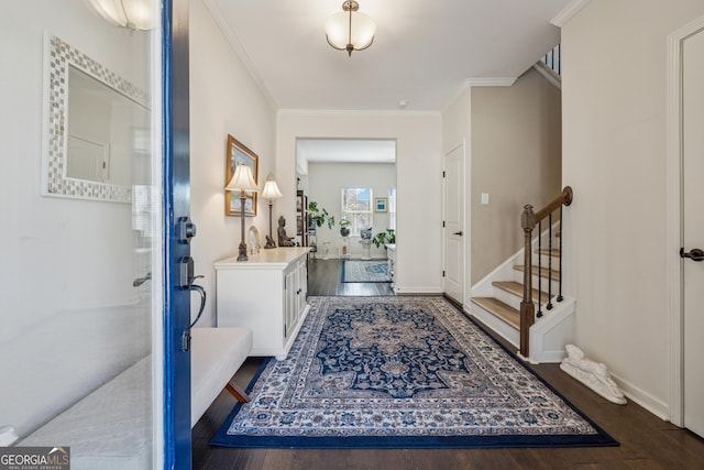 entrance foyer with ornamental molding, stairway, and wood finished floors