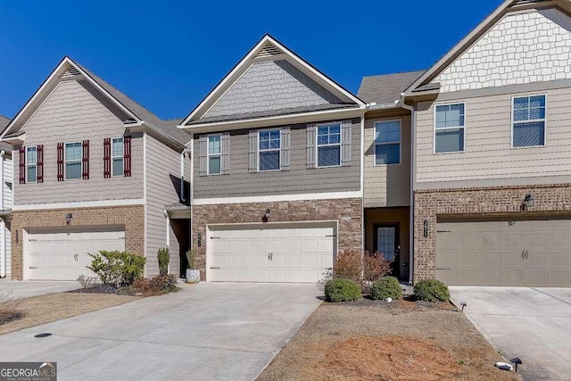 multi unit property featuring a garage and concrete driveway