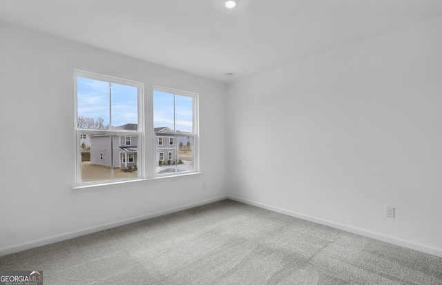 carpeted spare room with baseboards