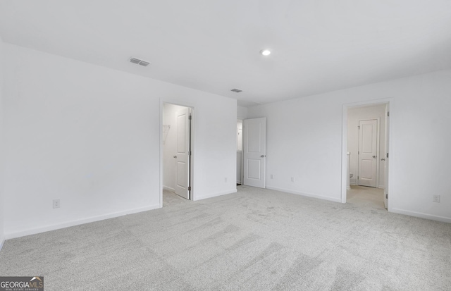 unfurnished bedroom featuring light carpet, visible vents, and baseboards