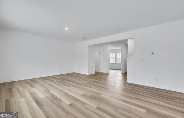 unfurnished room with light wood finished floors, baseboards, and recessed lighting